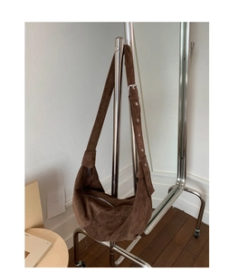 Détail du sac hobo en daim marron café avec fermeture éclair argentée et sangle