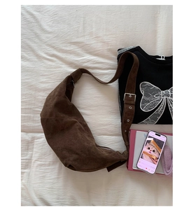 Gros plan détaillé d'un sac demi-lune en daim marron foncé avec des détails argentés