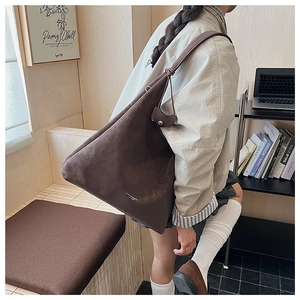 Détail du grand sac cabas en daim marron foncé avec texte blanc imprimé et bandoulière