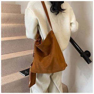 Detail of caramel suede tote bag with matching coin purse shown on a model