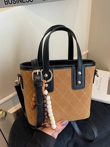 Borsa a secchiello marrone trapuntata con nappa in legno e borchie dorate lucide