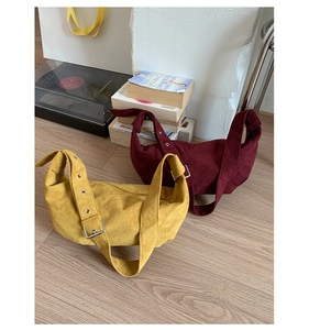 Détail de sacs vintage en daim jaune et bordeaux avec bandoulières à œillets