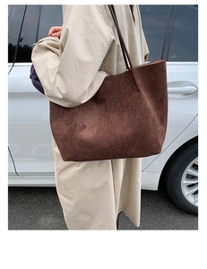 Deep brown matte suede tote bag shown on model with minimalist vertical stitching detail