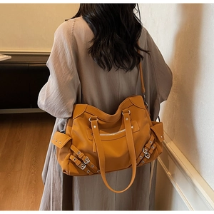 Détail d'un grand sac fourre-tout jaune gingembre avec rivets et bandoulière de style vintage