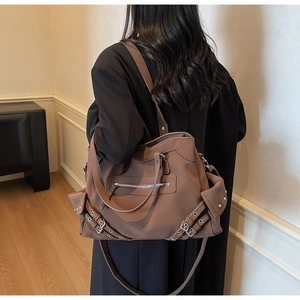 Vue arrière d'un grand sac cabas marron à rivets porté par un mannequin pour l'échelle
