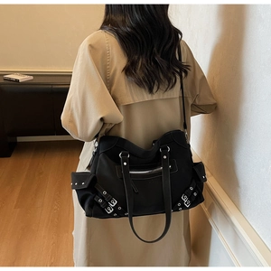Détail du sac cabas moto noir avec clous argentés et poches multiples sur le modèle
