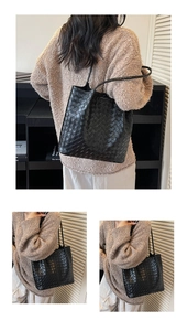Close-up of black woven leather texture and minimalist shoulder strap on large tote bag