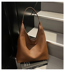 Detail of the brown woven leather texture on a spacious hobo shoulder bag