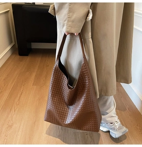 Detail shot of the woven texture and premium faux leather on this brown tote bag