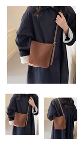 Detail view of coffee suede bucket bag showing soft texture and adjustable shoulder strap