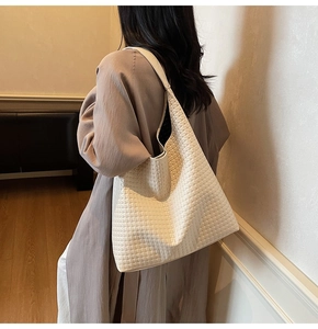 Detailed close-up of woven creamy-white hobo bag with high-capacity and soft silhouette