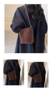 Detailed macro view of dark brown suede bucket bag featuring embossed fashion lettering