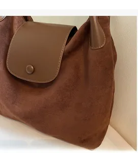 Close-up of frosted soft leather texture on a large capacity brown tote bag