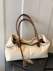 Minimalist beige corduroy tote bag with brown leather handles and gold buckle accents