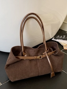 Brown corduroy tote bag with leather strap detail for women shown in a lifestyle setting