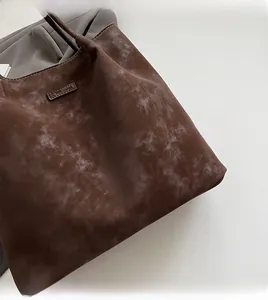 Close-up of dark brown tote bag showing vintage textured fabric and durable stitching