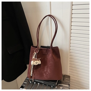 Close-up of deep burgundy tote bag with cute dog charm and polka dot scarf detail