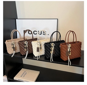 Dettaglio delle borse tote pieghettate in cinque colori con ciondoli decorativi moda