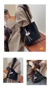 Detail of black suede tote bag featuring a cute white plush doll and tassel charm
