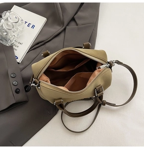 Dettaglio borsa bowling in pelle kaki che mostra l'interno spazioso con fodera e tasche extra