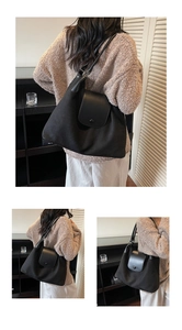 Detail of black large tote bag showing matte fabric texture and leather strap design