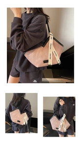 Detail of pink corduroy tote bag with signature white branded ribbon and black handles