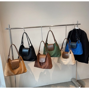Showcase of minimalist suede tote bags in various vintage colors on a display rack