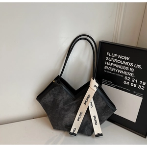 Detail of grey corduroy tote bag featuring unique V-shaped opening and woven logo strap