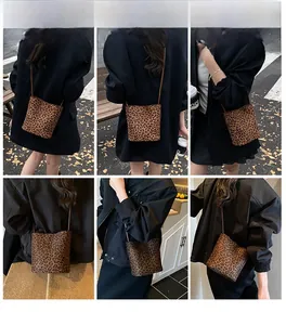 Détail du sac seau tendance à imprimé léopard porté en bandoulière et à l'épaule