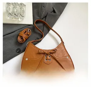 Close-up of caramel brown PU leather bag with bow detailing and textured finish