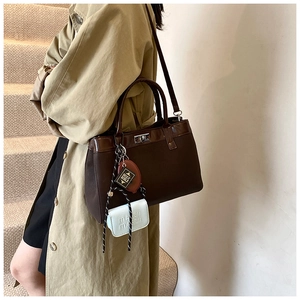 Detail view of coffee brown vintage tote bag with Bible charms and mini pouch accessory