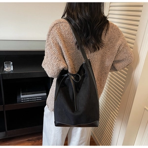 Detailed back view of a large black bucket bag showing suede and leather texture