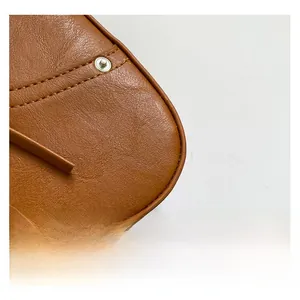 Close-up of caramel lychee grain leather texture with premium silver buckle and stitching