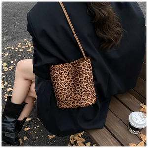 Vue détaillée du sac seau à imprimé léopard avec bandoulière en cuir brun en décor automnal