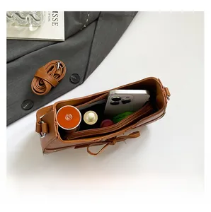 Internal view of brown leather handbag showing large capacity for phone and cosmetics