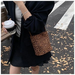 Gros plan du sac seau à imprimé léopard avec bandoulière et texture daim doux