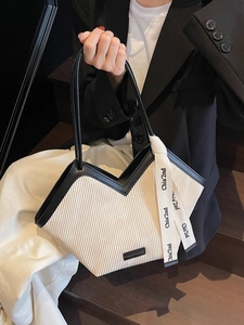 Fashionable high-capacity pleated tote bag in beige and black shown on a model