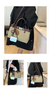 Detail of khaki canvas tote with brown leather trim, silver hardware and cute charms