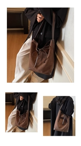 Macro view of dark brown suede bucket bag featuring drawstring detail and smooth leather trim