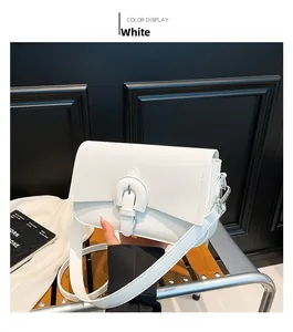 Detail of white minimalist crossbody bag showing circular strap buckle and texture