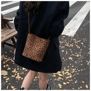 Détail d'un sac seau léopard porté en bandoulière dans un style de rue automnal