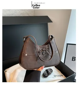 Detail of coffee brown underarm bag with decorative bow and matte leather texture