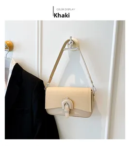 Detailed close-up of khaki baguette bag with woven texture and leather-wrapped buckle