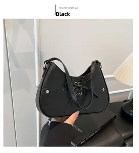 Close-up of black leather hobo bag with bow tie and silver eyelets for commute