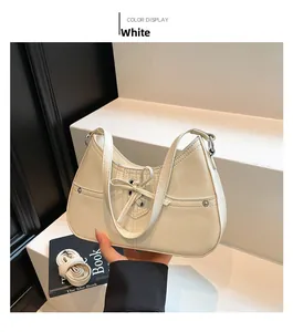 Detail of white leather underarm bag featuring decorative bow ties and silver ring buckles
