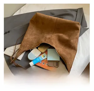 Εσωτερική όψη της καφέ σουέτ τσάντας tote με iPad και είδη καθημερινής χρήσης