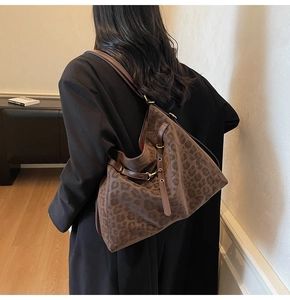 Detailed view of large leopard print hobo bag with adjustable brown leather strap