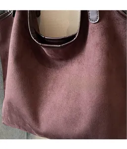 Close-up of premium dark brown suede fabric texture on a soft oversized tote bag