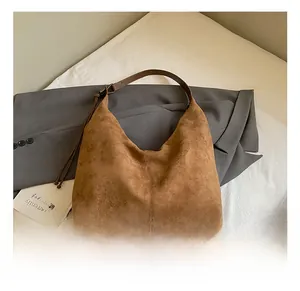 Κοντινό πλάνο vintage καφέ hobo τσάντας με λεπτές ραφές και ματ υφή σουέτ