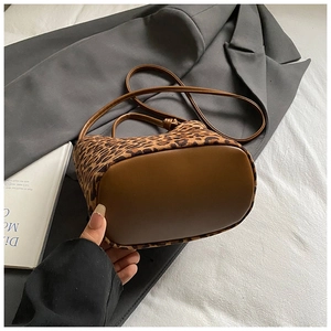 Vue détaillée du sac seau léopard avec fond et bandoulière en cuir marron de qualité